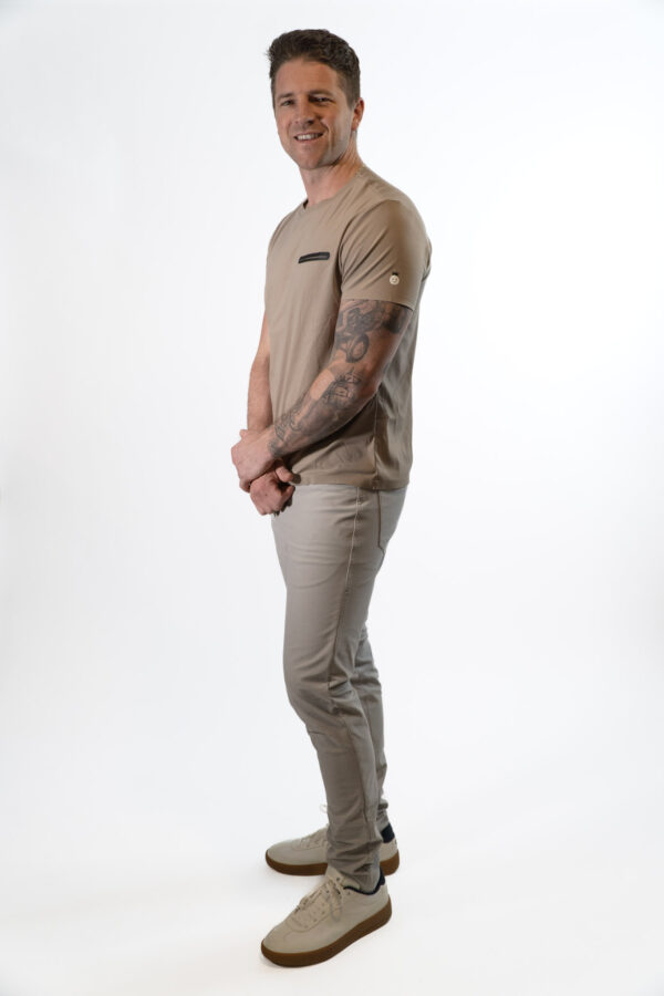 Side profile of model wearing taupe Good Dink athletic shirt for pickleball