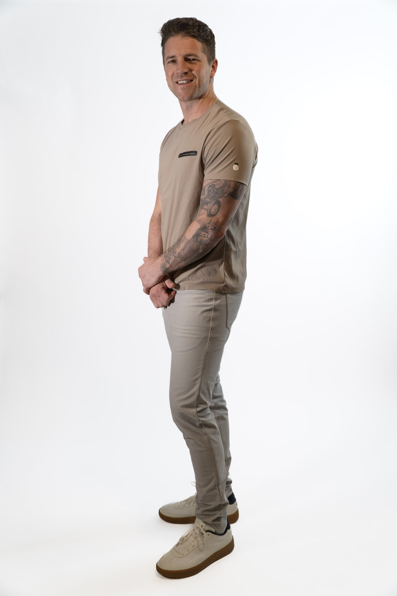 Side profile of model wearing taupe Good Dink athletic shirt for pickleball